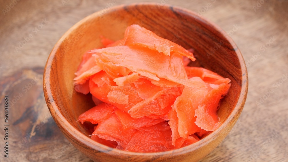 Pickled ginger slices in wooden bowl, close up Pickled ginger slices in wooden bowl, close up