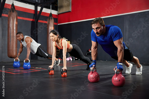 sportsman doing push up on two kettlebells in the gym