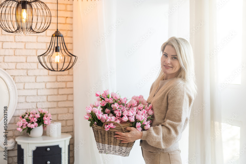 woman decorates her house with flowers. woman collects a bouquet at home in the kitchen. spring mood. woman decorates her house with flowers. woman collects a bouquet at home in the kitchen. spring mood.