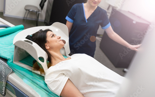 Radiologist with a female patient in the room of computed tomography