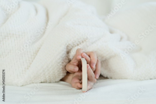 hand holding phone in bed © Xiuxia Huang