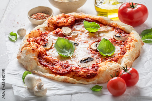 Delicious and hot pizza made of mushrooms and basil.