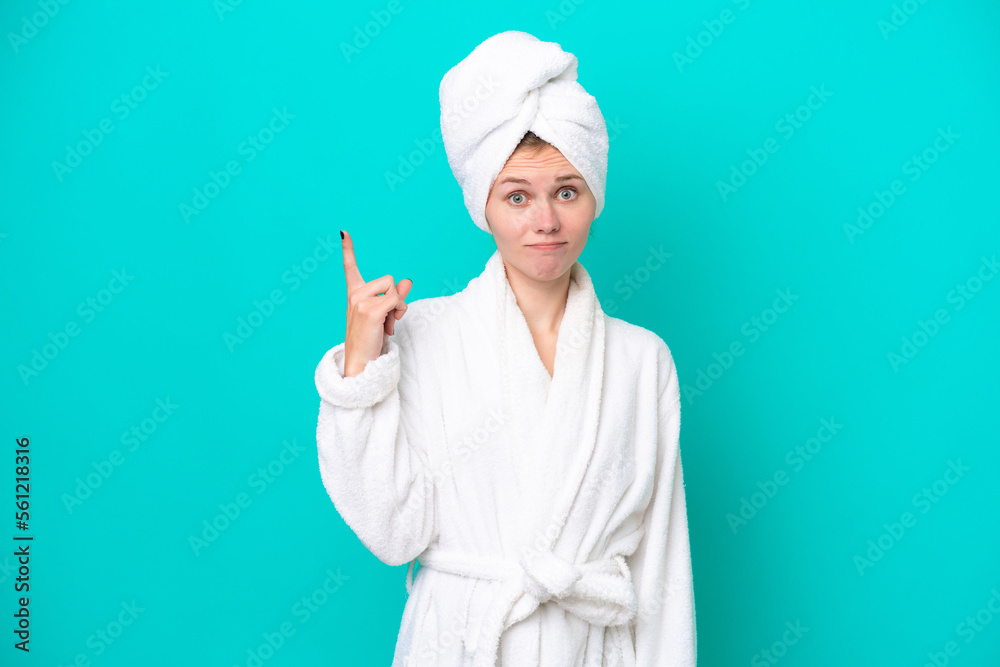 Young woman in a bathrobe isolated on blue background pointing with the index finger a great idea Young woman in a bathrobe isolated on blue background pointing with the index finger a great idea