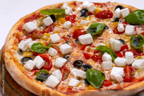 freshly baked pizza with feta cheese slicers on white background