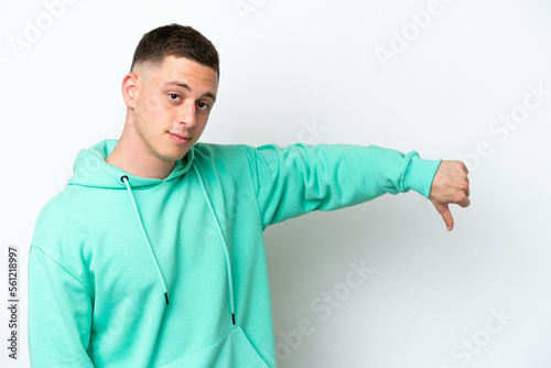 Young brazilian man isolated on white background showing thumb down with negative expression © luismolinero