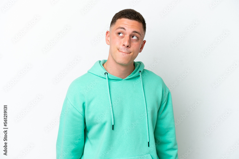Young brazilian man isolated on white background having doubts while looking up Young brazilian man isolated on white background having doubts while looking up