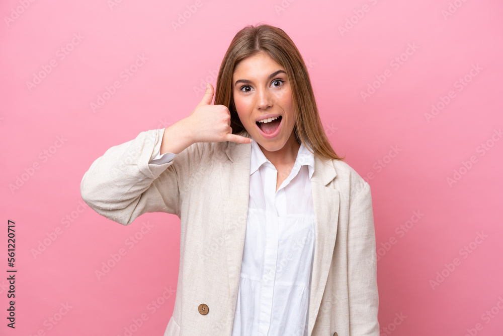 Young caucasian woman isolated on pink bakcground making phone gesture. Call me back sign Young caucasian woman isolated on pink bakcground making phone gesture. Call me back sign