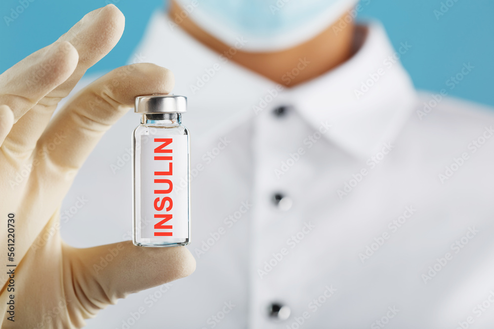 The doctor holds a syringe for injections and an ampoule with insulin for the treatment of Diabetes The doctor holds a syringe for injections and an ampoule with insulin for the treatment of Diabetes