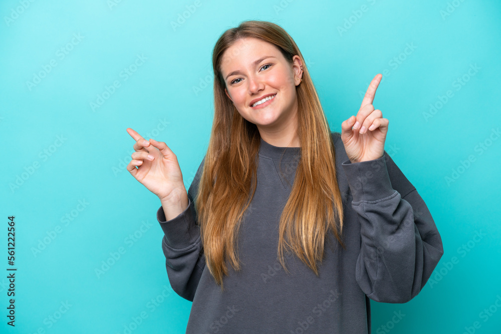 Young caucasian woman isolated on blue background pointing finger to the laterals and happy Young caucasian woman isolated on blue background pointing finger to the laterals and happy