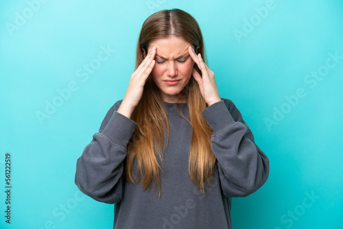 Young caucasian woman isolated on blue background with headache