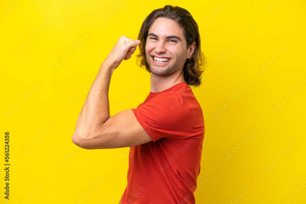 Caucasian handsome man isolated on yellow background doing strong gesture Caucasian handsome man isolated on yellow background doing strong gesture