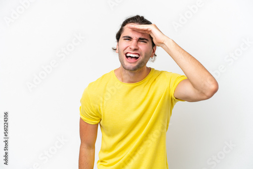 Caucasian handsome man isolated on white background looking far away with hand to look something