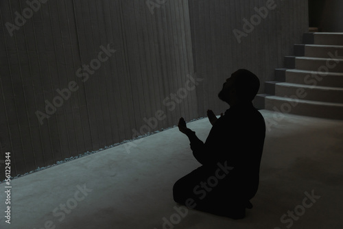 Muslim man praying in the mosque with raising hands. photo