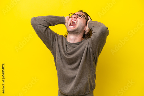 Foto Caucasian handsome man isolated on yellow background stressed overwhelmed