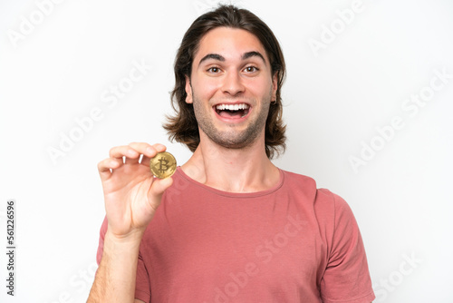 Young handsome man holding a Bitcoin isolated on white background with surprise and shocked facial expression