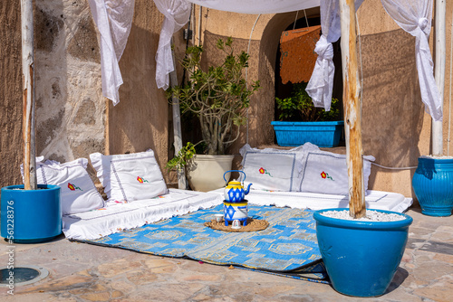 Arabic majlis, traditional Arabic seating area on the floor with white decorated cushions, blue rug and tea pot, Old Dubai, Deira, UAE. photo