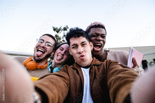 Happy diverse friends taking selfie © DMegias