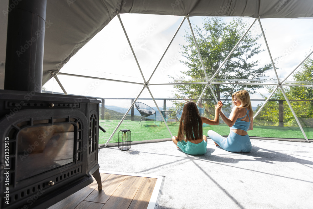 mother and daughter yoga in a glamping dome tent