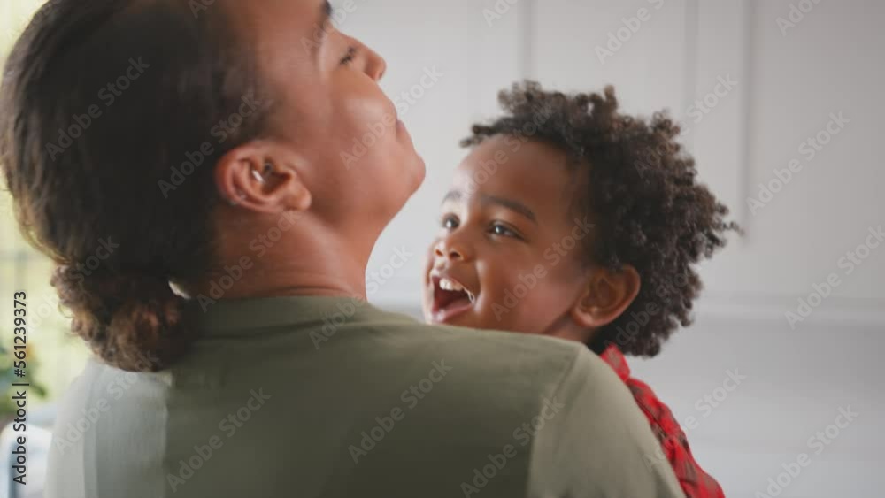 Loving Mother Carrying And Hugging Son At Home In Family Kitchen Loving Mother Carrying And Hugging Son At Home In Family Kitchen