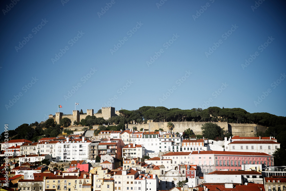 View of Sao Jorge Castle against clear sky with houses in foreground View of Sao Jorge Castle against clear sky with houses in foreground