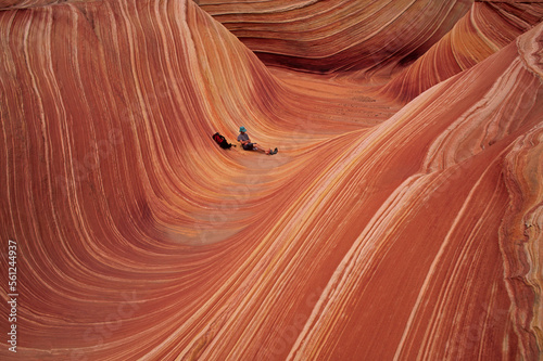 A desert hiker relaxes in the surreal landscape of a sandstone slot canyon photo