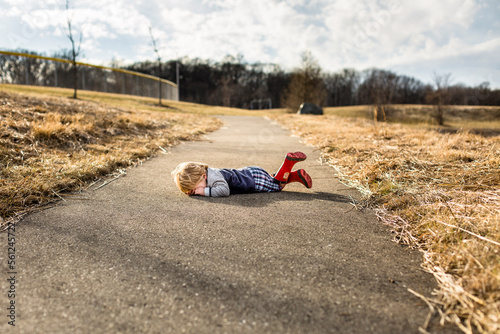 Toddler boy having a tantrum on walking path photo