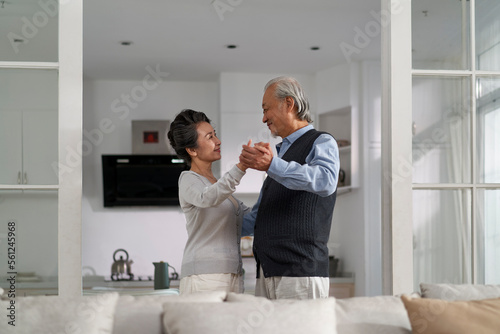 Photography loving asian old couple dancing at home