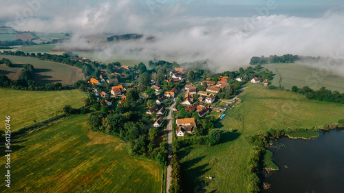 Aerial view of small village in fog.Top view of traditional housing estate in Czech. Looking straight down with a satellite image style.Houses from above, real estate concept.Country road urban scene