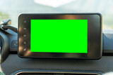 Close-up of multimedia screen with chroma key green background, inside a modern car. 