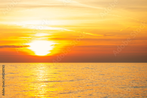 sunset on the sea, the golden pink sun sets behind the clouds in the sky © yta