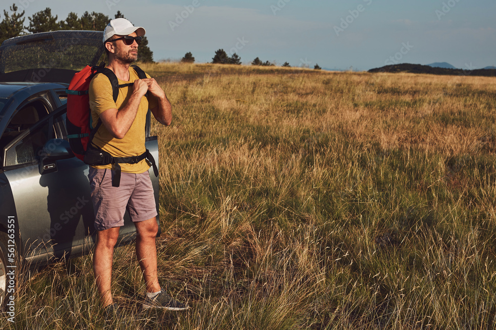 Man camping and hiking in nature, unpacking from car outdoors, recreation and hobbies. Man camping and hiking in nature, unpacking from car outdoors, recreation and hobbies.