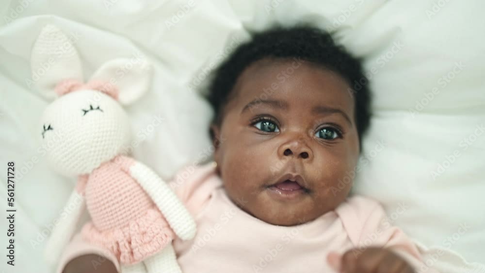 African american baby smiling confident lying on bed at bedroom African american baby smiling confident lying on bed at bedroom