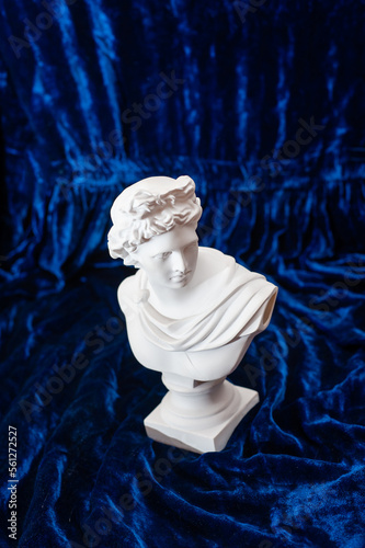 sculpture of apollo on dark blue velvet. copy space