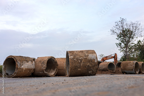 Low angle view of large old concrete pipes, which are damaged and soiled with mud..