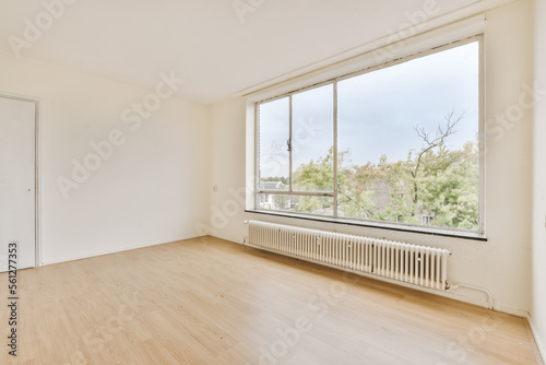 an empty room with wood floor and large window looking out onto the cityscapea photo taken from inside photo