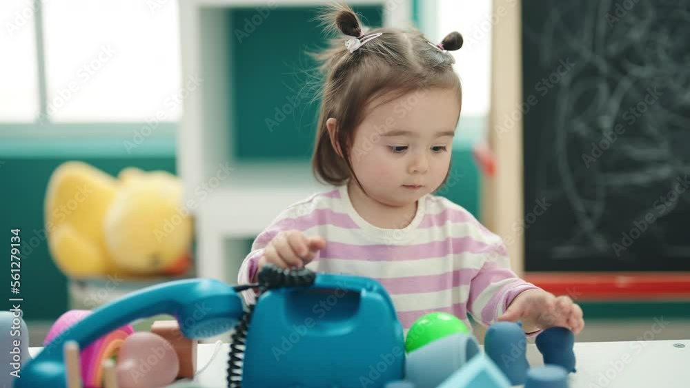 Adorable chinese toddler playing telephone toy standing at kindergarten Adorable chinese toddler playing telephone toy standing at kindergarten