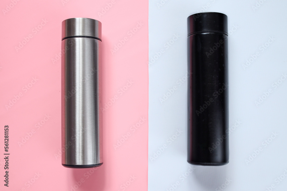 Silver and black thermos for mock up on white pink background 