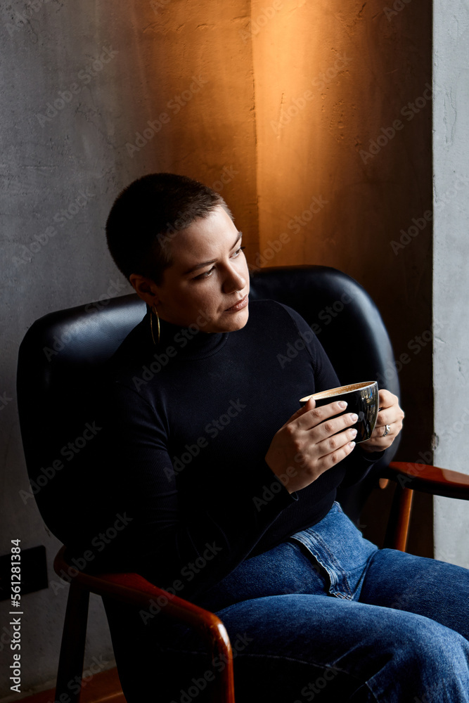 A woman sitting in a cafe, drinks coffee. A woman sitting in a cafe, drinks coffee.