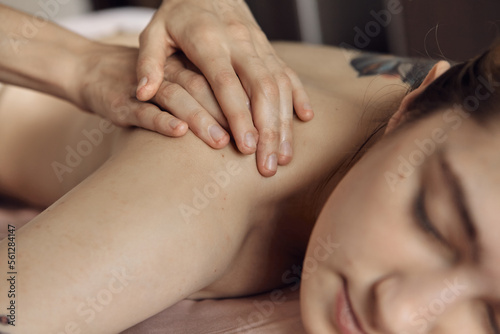 Massage session: woman receiving back massage from professional masseur. Attractive caucasian woman having relaxing massage on the back in spa salon. Healthy lifestyle and body care concept