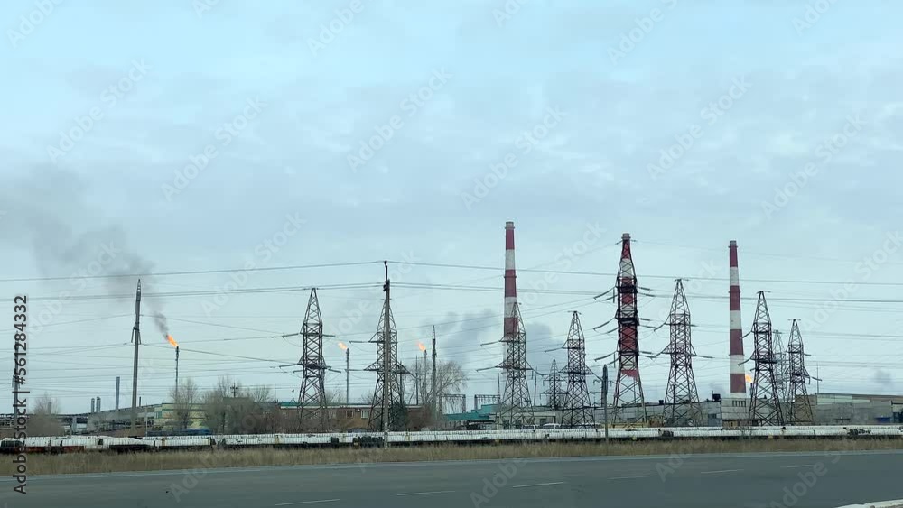 Gas processing plant. View of gas torches and striped pipes of a thermal power plant. Air pollution and ecology. Oil production and refining. Gas processing plant. View of gas torches and striped pipes of a thermal power plant. Air pollution and ecology. Oil production and refining.