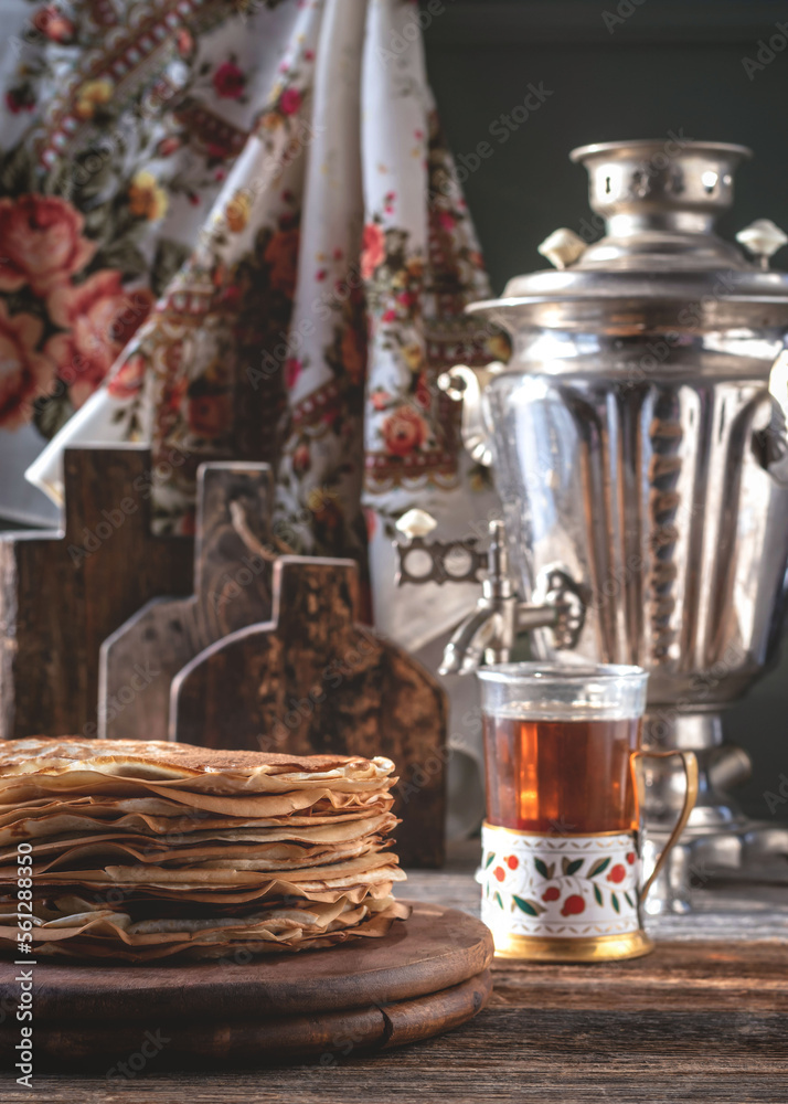 Pancakes for Maslenitsa. A stack of Russian thin pancakes. Samovar and tea on the table.Traditional Russian festive food. Country style.