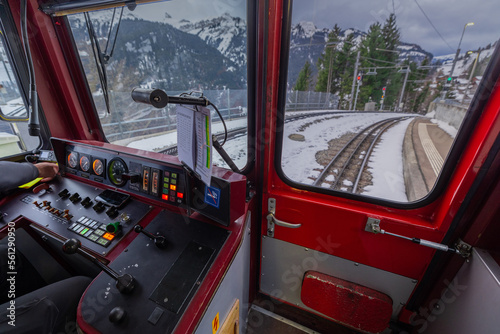 Inside of the drivers cab of older style EMU of a narrow gauge railway from Lauterbrunnen to Jungfraujoch in winter time. Visible commands and rails in the front.