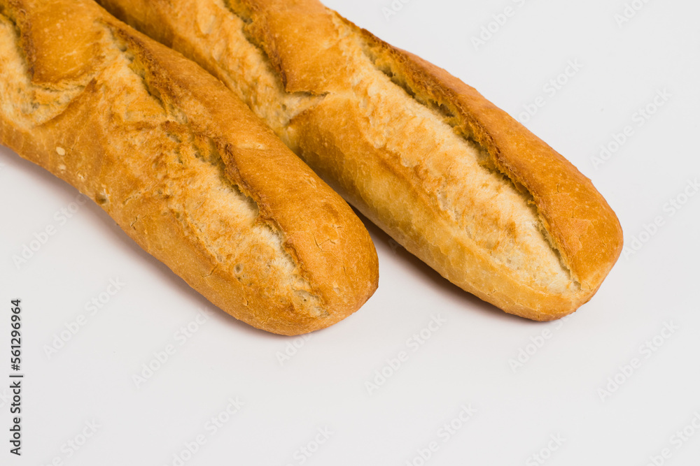 French baguettes on a white background with copy space. Delicious appetizing crust of a bun close-up