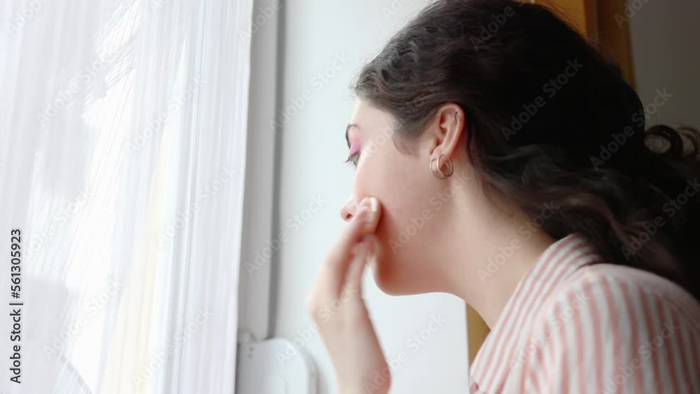 Side view of young Caucasian woman applying makeup. Close up of girl using foundation with sponge. Concept of beauty routine Side view of young Caucasian woman applying makeup. Close up of girl using foundation with sponge. Concept of beauty routine
