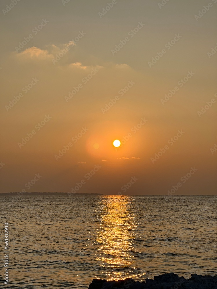 Sunset view of sky and sea. Clouds and ocean, palm trees, Maldives, Kulhudhuffushi city, birds