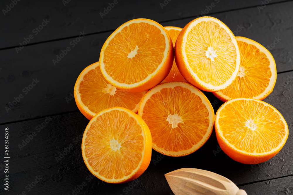 Bright halves of oranges on a wooden table. Halves of juicy oranges on black boards Bright halves of oranges on a wooden table. Halves of juicy oranges on black boards