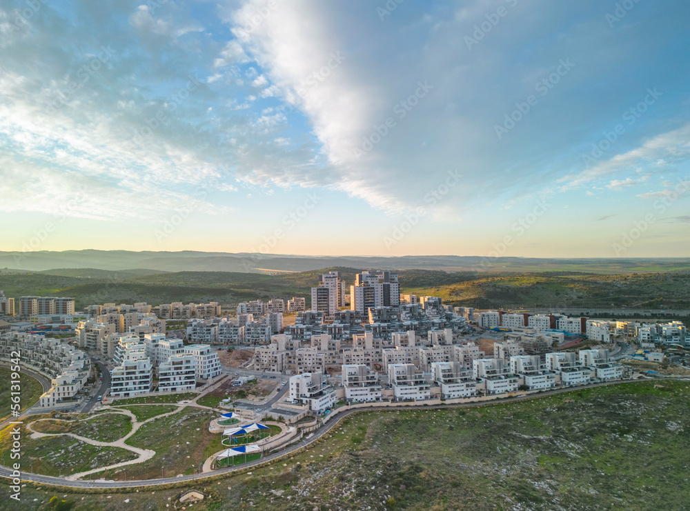 Modiin, Israel, January 12, 2023 Construction of a multi-story residential building and a large new residential area overlooking a green park with trees and a lawn next to residential buildings