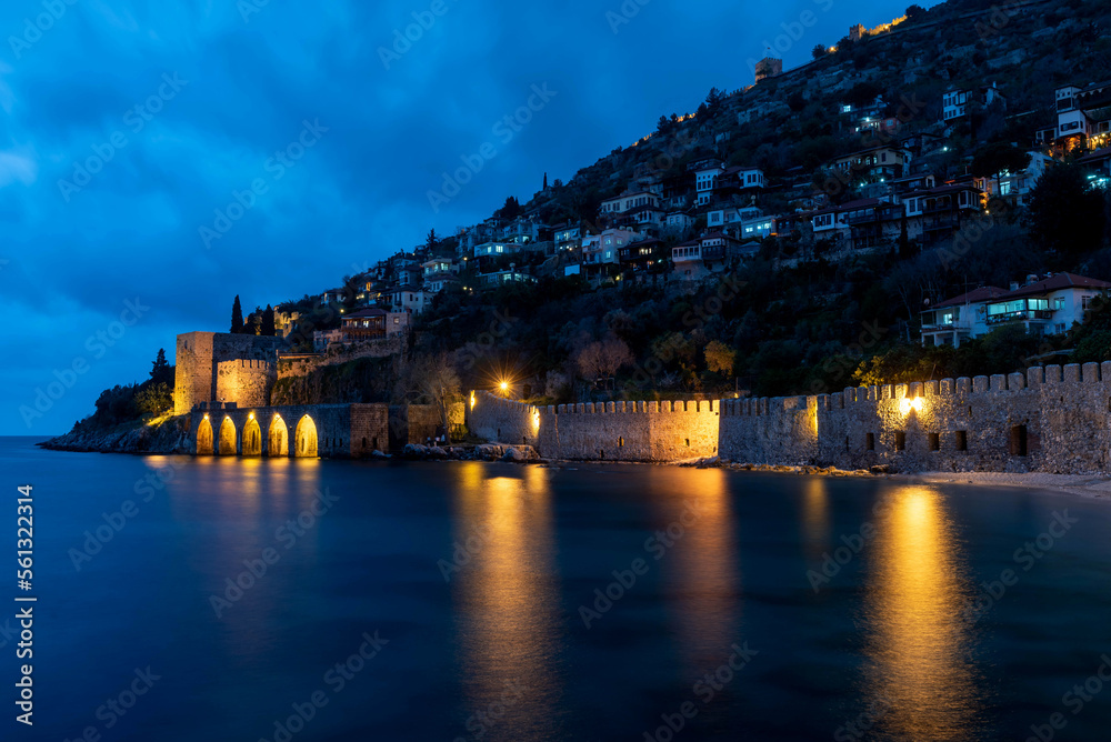 Naklejka premium Alanya, Turkey. April 8th 2021.Beautiful view of Alanya peninsular and the old Shipyard and castle walls from the harbour at night