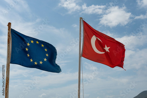 Fototapeta Naklejka Na Ścianę i Meble -  Alanya, Turkey. April 8th 2021.Tattered Turkish and European Flags flying on the beach in Alanya on the Mediterranean Coast, Turkey.