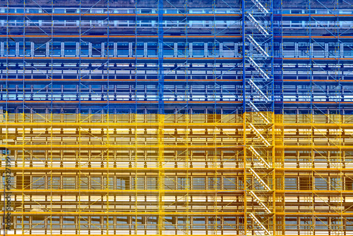 Baustelle mit Gerüst und Bauschutznetz in den Nationalfarben der Ukraine als Symbol für den Wiederaufbau an einem Gebäude in der Frankfurter Innenstadt